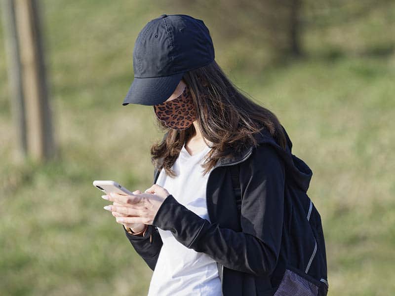Girl getting text with mask and bag